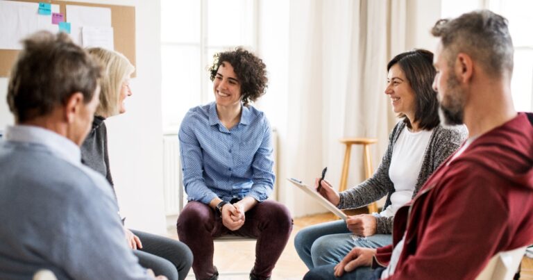 Group therapy session for alcohol addiction recovery with counselor and participants in supportive treatment environment