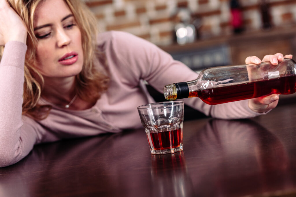 Woman exhibiting alcohol addiction symptoms