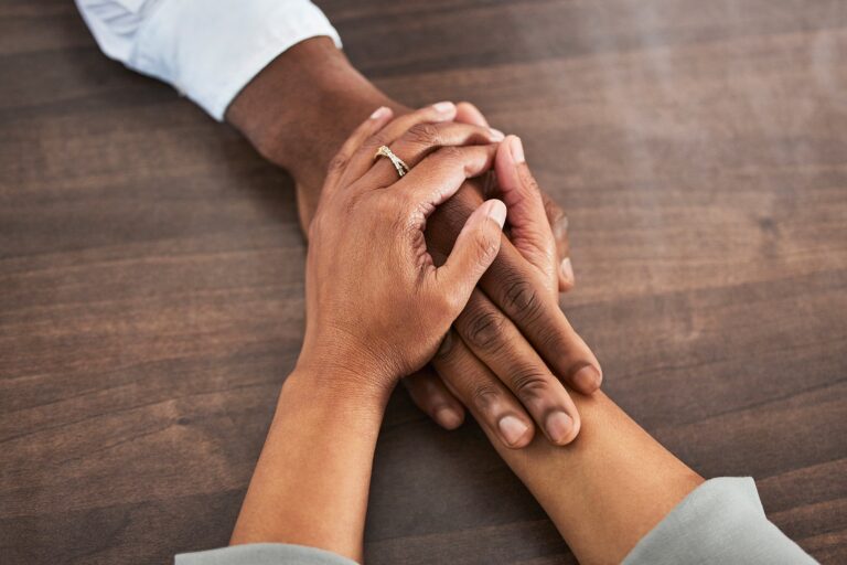 Holding hands with a loved one and trying to help them with alcohol addiction
